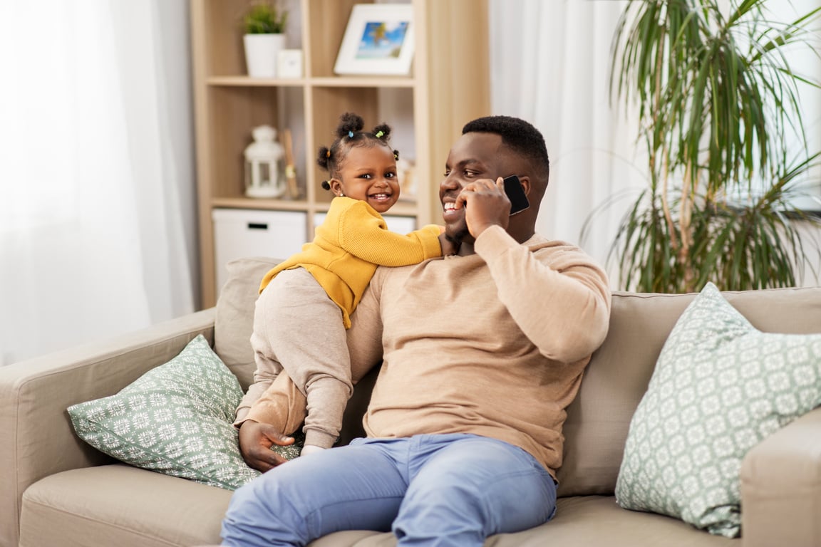 Father Talking on the Smartphone with Baby at Home 